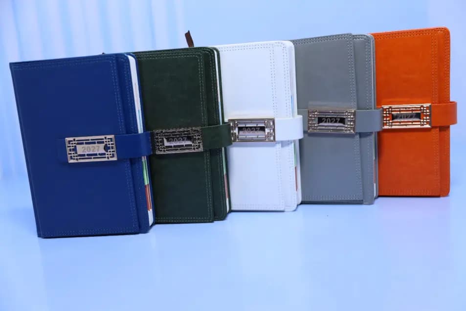 2027 A5 T203 executive diaries in blue, dark green, white, grey and orange with decorative rectangular badges