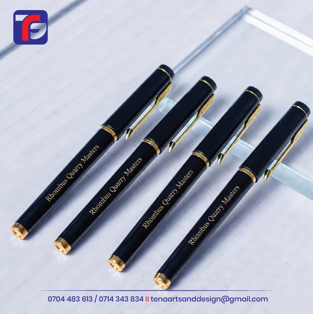 Four black branded executive pens with gold-toned clips and Rhombus Quarry Masters lettering along the barrels.