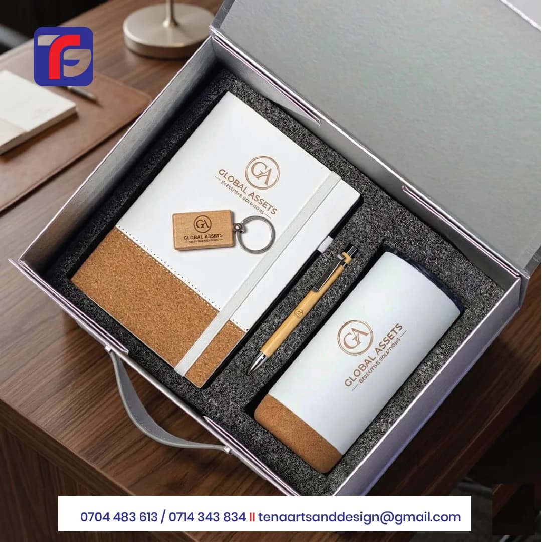 White corporate gift set with a notebook, tumbler, wood-look pen and keyring displaying Global Assets branding inside a grey presentation box.