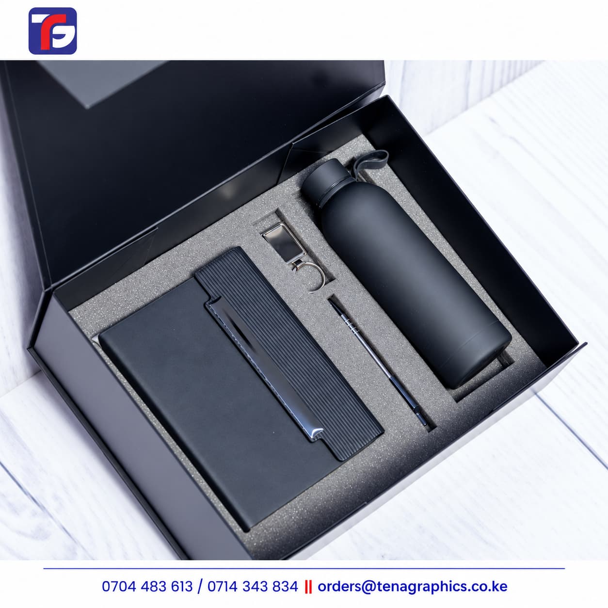 Black E128 end of year corporate gift set with notebook, bottle, pen and metal keyholder in a fitted foam insert