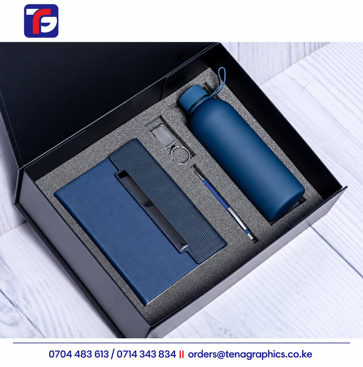 Blue E128 end of year corporate gift set with notebook, bottle, pen and metal keyholder in a black presentation box