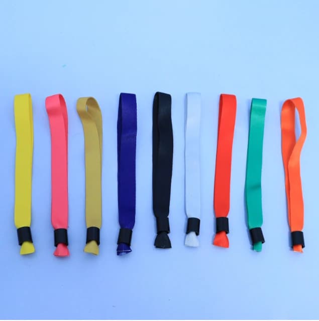 Assorted coloured fabric wristbands with black slider-style fastenings