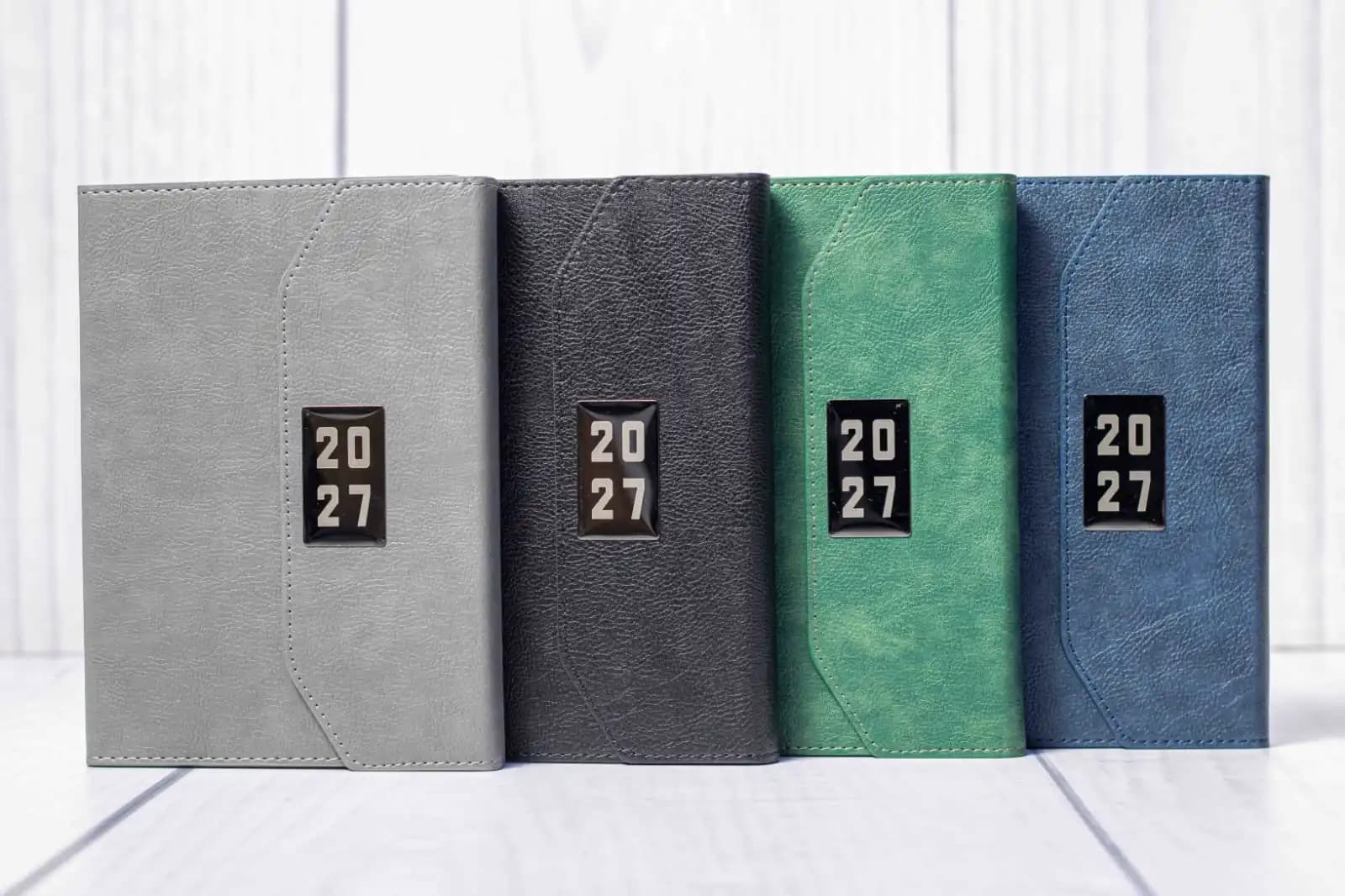 A5 T200 Executive Diaries 2027 in grey, black, green and blue with stitched flap covers and rectangular year badges