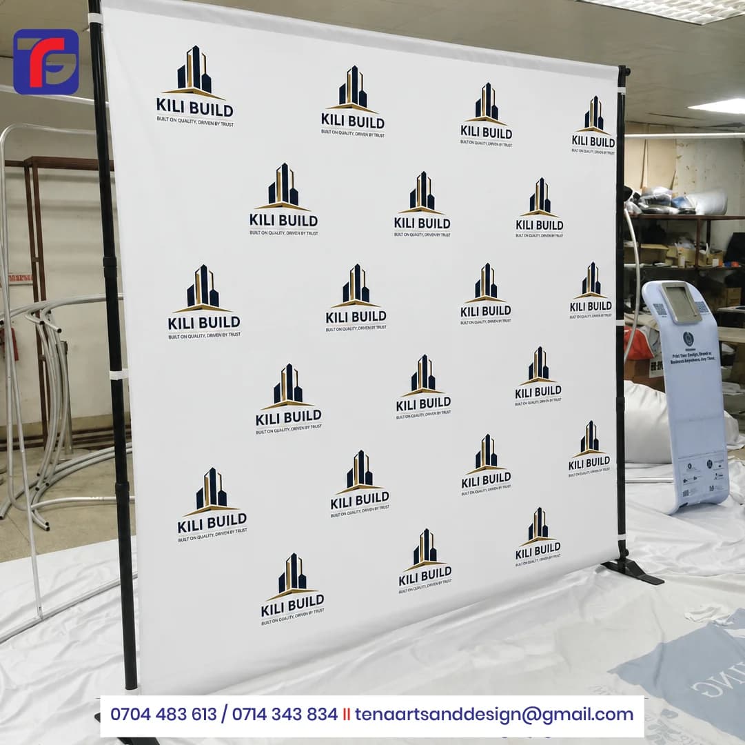 White step and repeat backdrop with navy and gold KILI BUILD logos, black support uprights and floor feet.