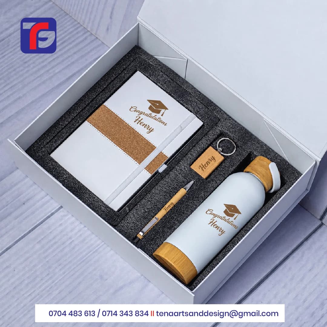 Personalised graduation gift set with a white notebook, bottle, brown pen and keyring displaying Henry name branding.