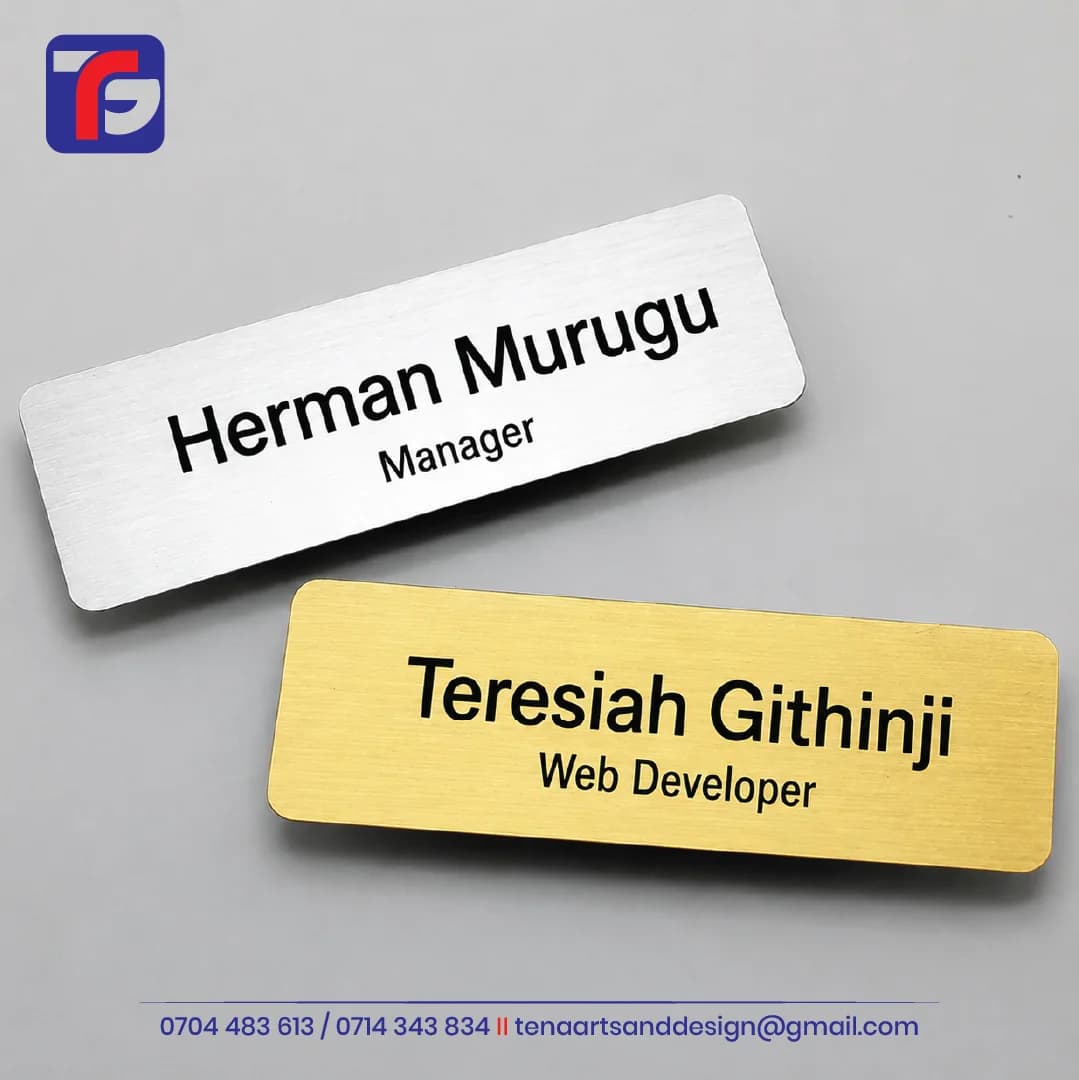 Silver and gold-coloured engraved staff name tags with black employee names, job titles and rounded corners.