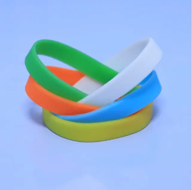 Green, white, orange, blue and yellow loop wristbands photographed under normal lighting