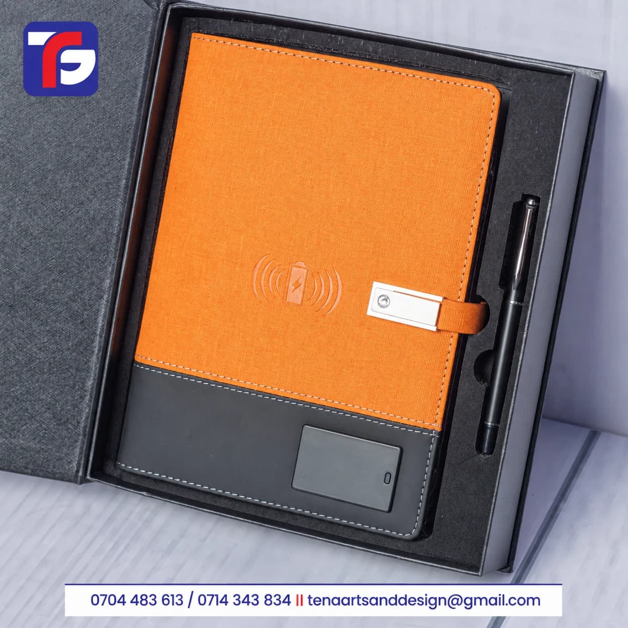 Brown two-tone executive notebook pen set with stitched edges, silver-tone strap detail and black pen in a fitted presentation box