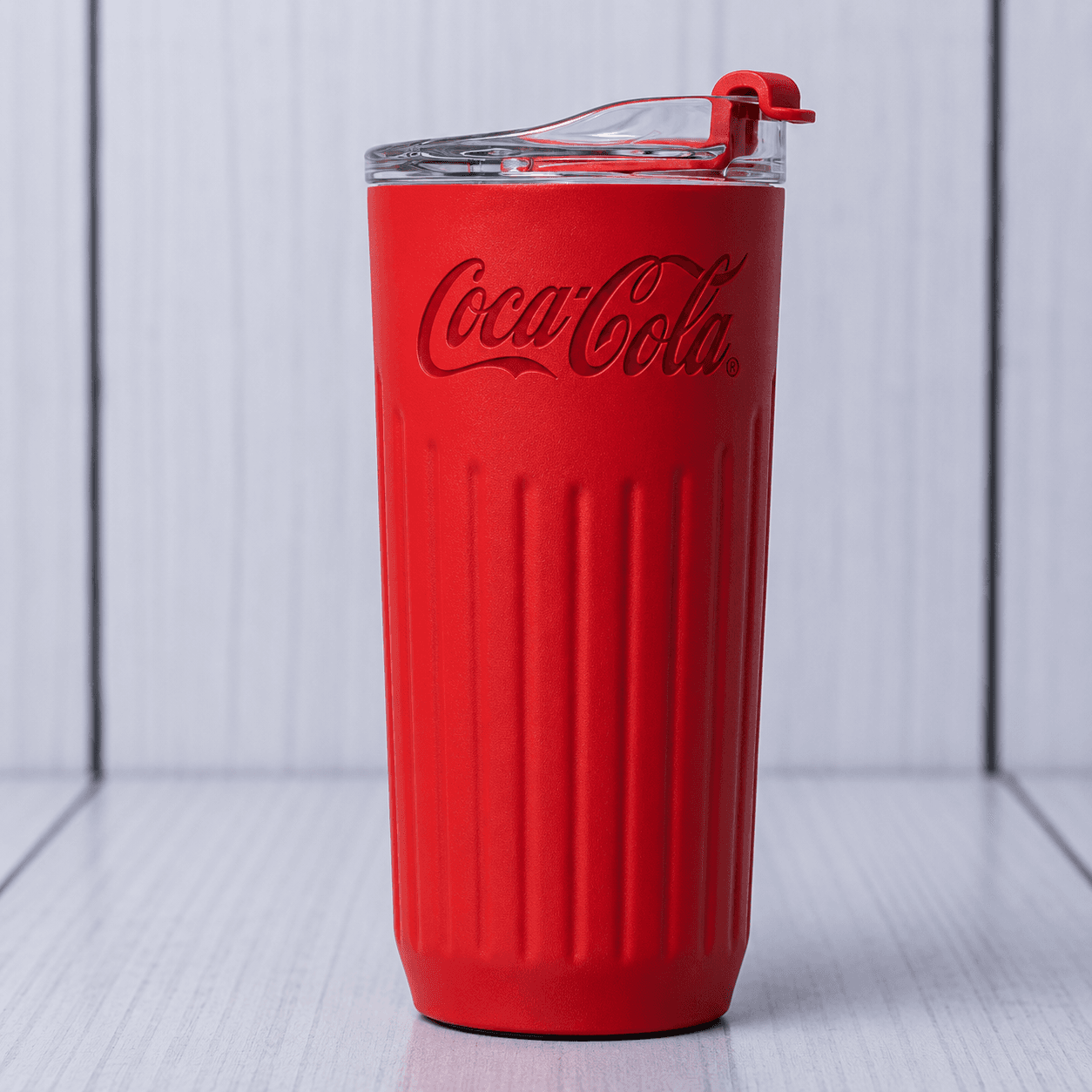 Red ribbed tumbler Kenya with Coca-Cola branding, a clear lid and red drinking-opening closure.