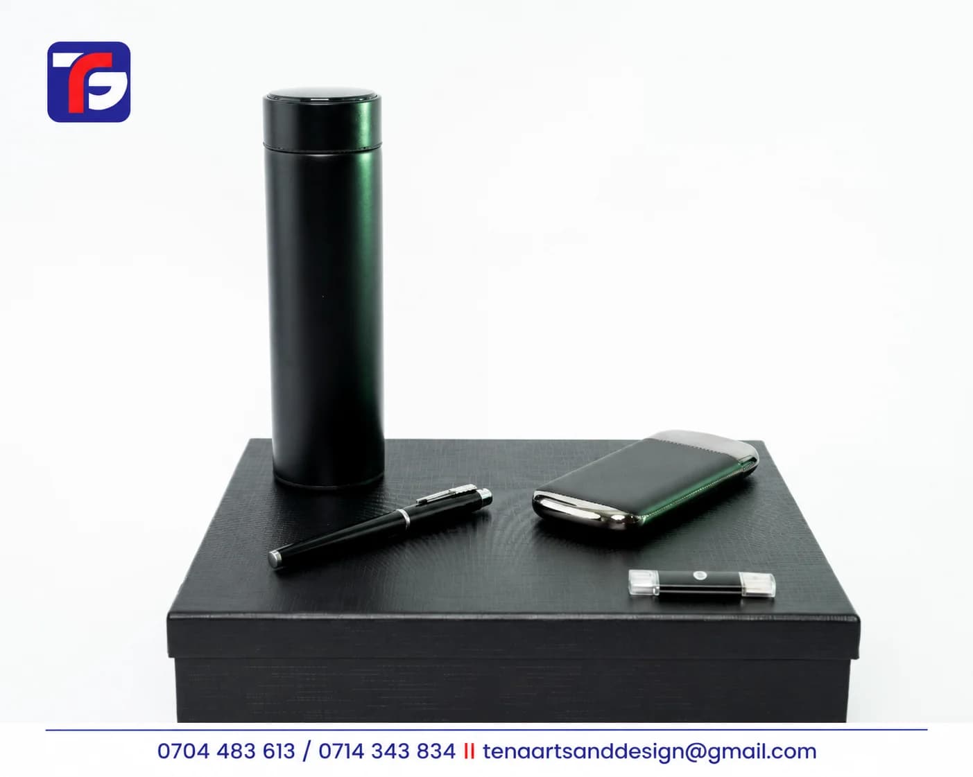 Black executive flask and tech gift set with a pen and two compact tech accessories displayed on a matching gift box